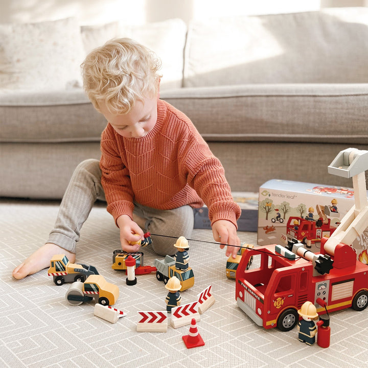 Kid playing with Tender Leaf Toys Wooden Fire Engine and Firefighter Play Set