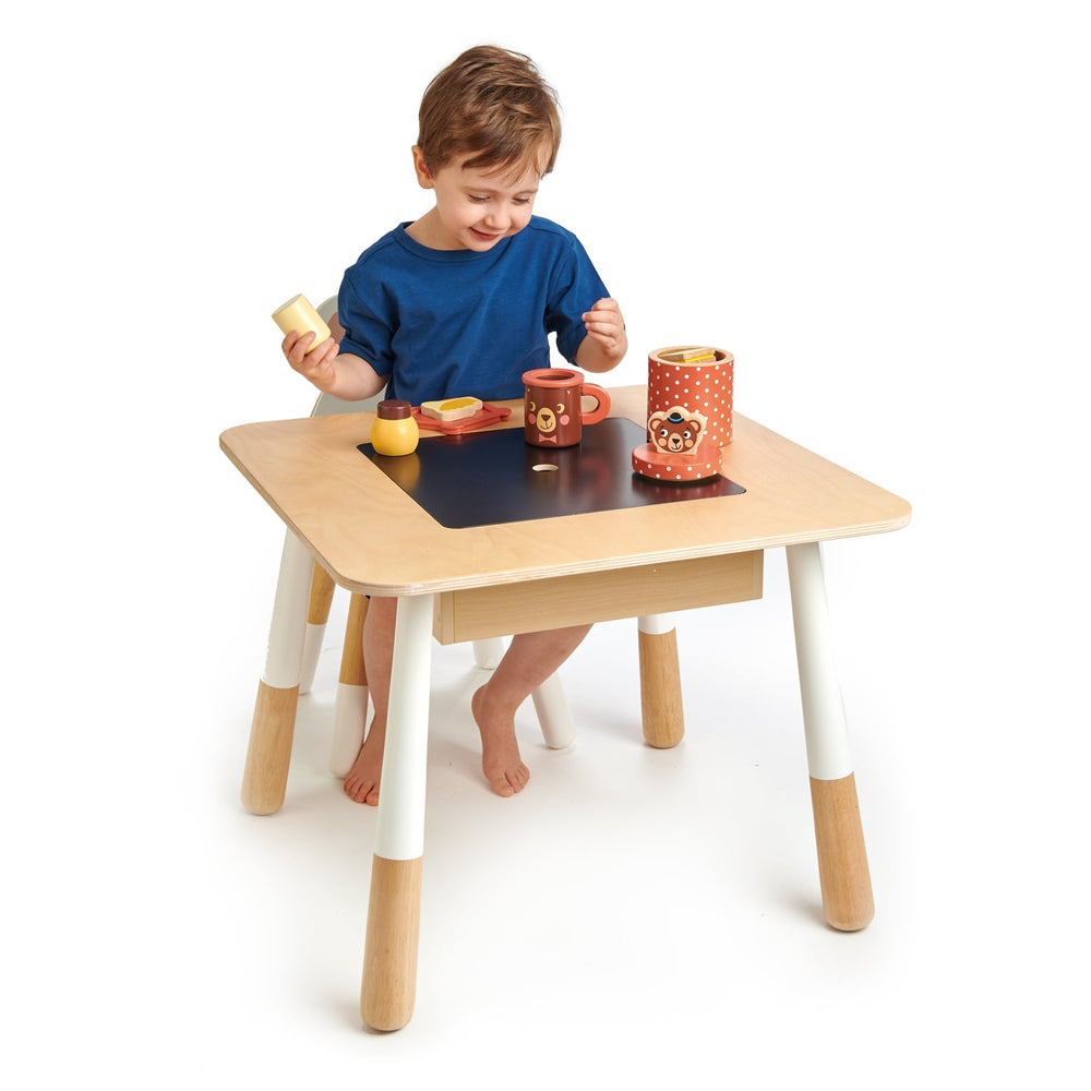 Child playing on Tender Leaf Toys Wooden Play Table with Chalkboard and Storage