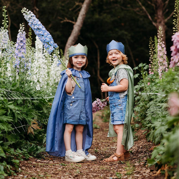 Child wearing Sarah's Silks Northern Coast Playsilk crown and cape in a flower field.