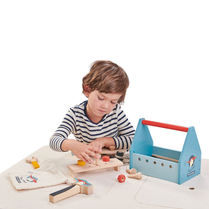 A child tightens the wooden screws from the Tender Leaf Toys Wooden Tap Tap Toolbox.