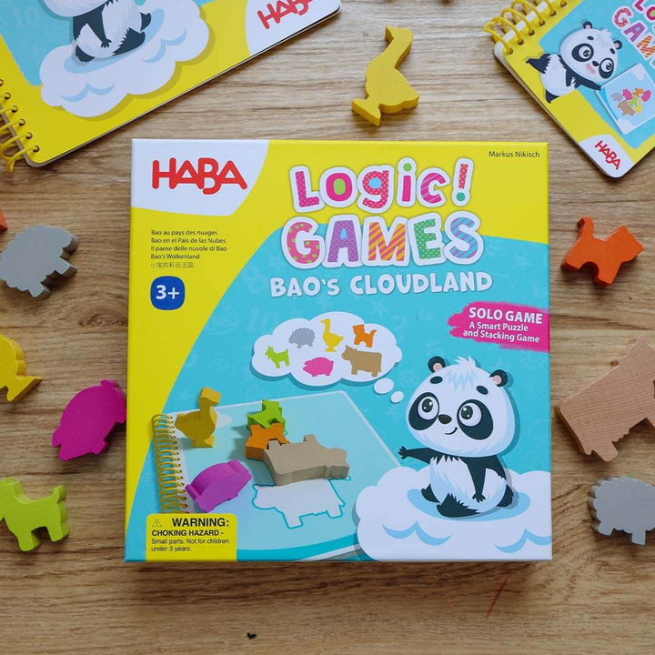 HABA Logic! Games Bao's Cloudland game box on a wooden surface with animal puzzle pieces.