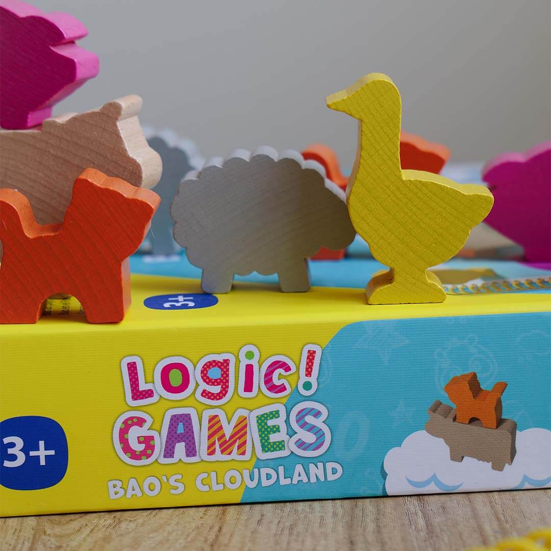 Colorful wooden animal pieces on a 'Logic! Games Bao's Cloudland' box.