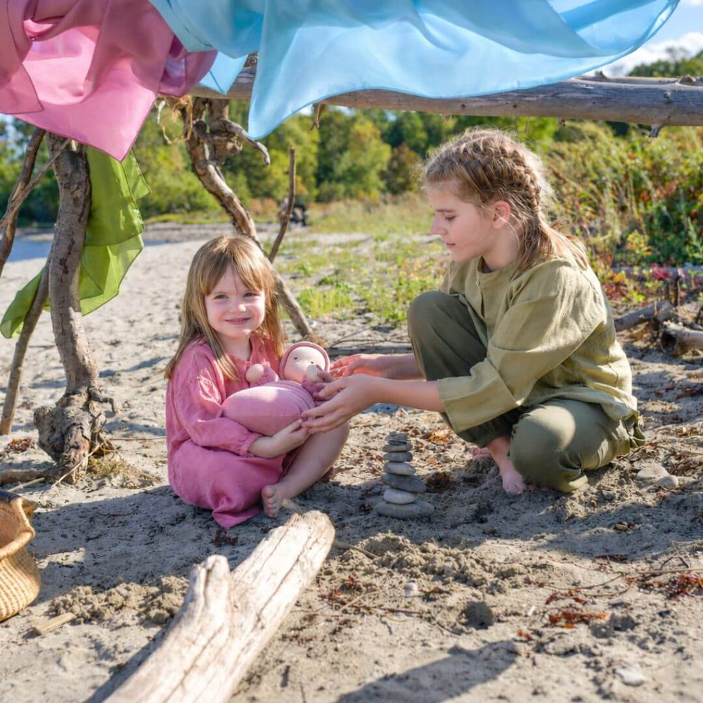 Two girls in a beach fort with Bella Luna Toys Play Silks hanging from it's branches.
