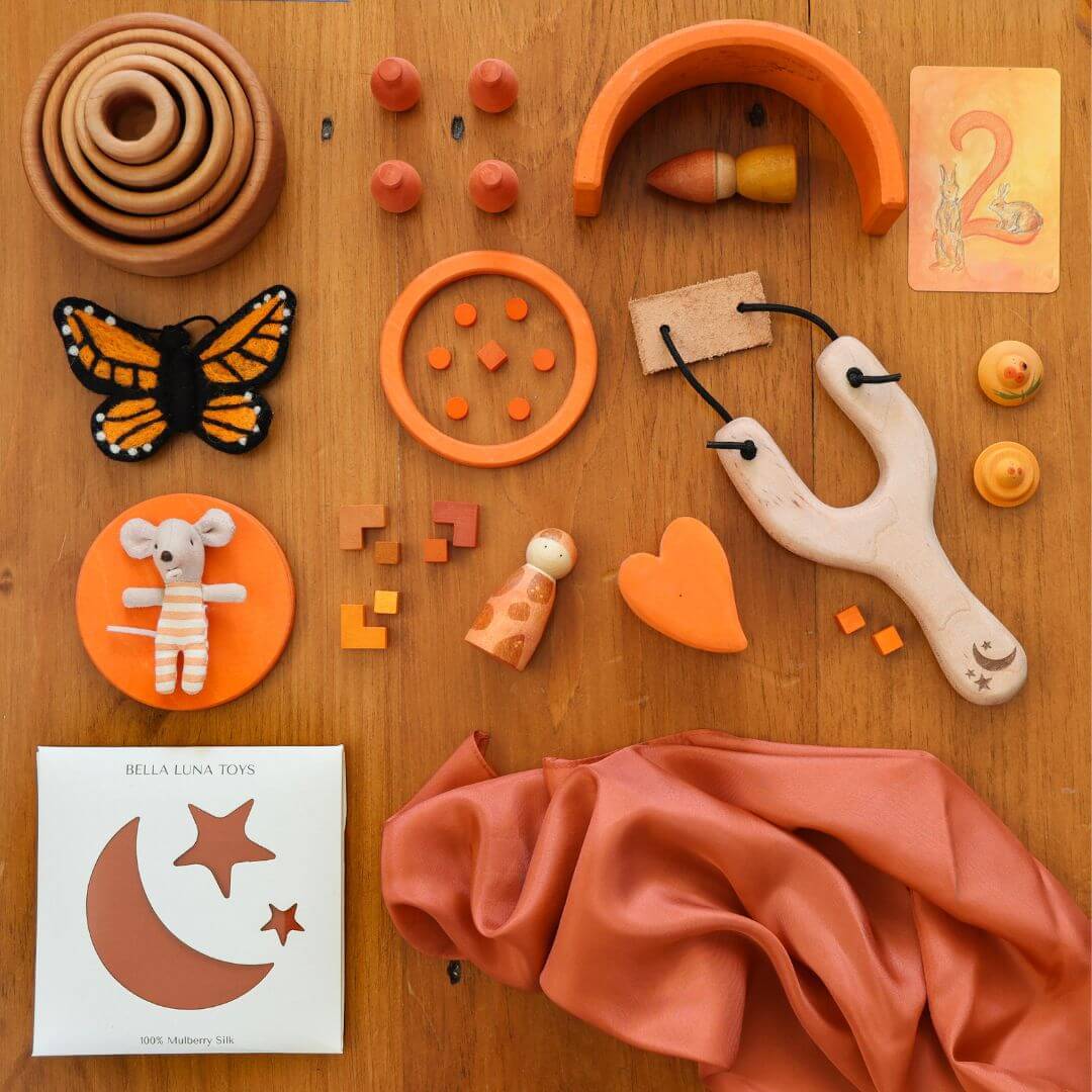 Bella Luna Toys Orange Play Silk with a collection of other orange items.