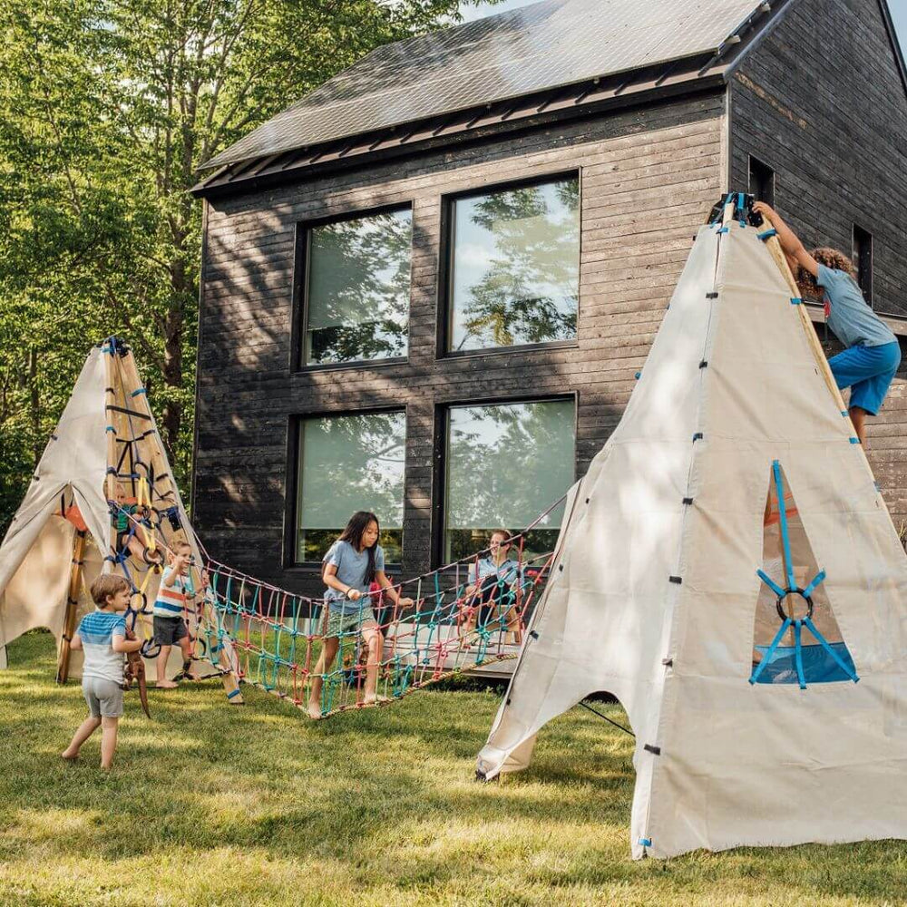 Children playing outdoors on a Bijou Rambler Rope Bridge connected between two Mainstays in a backyard - Bella Luna Toys