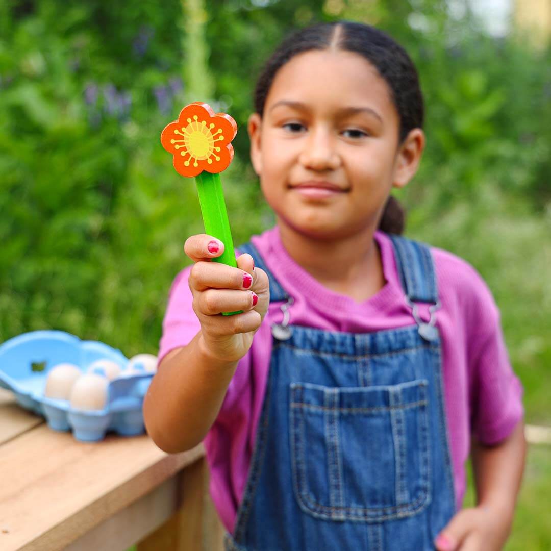 A girl is holding a wooden flower.