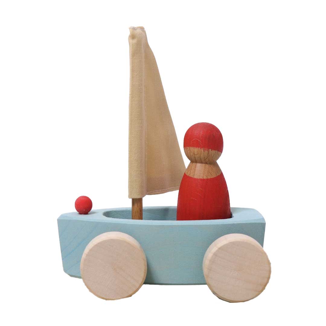 Wooden toy boat with a sail and wheels on a white background