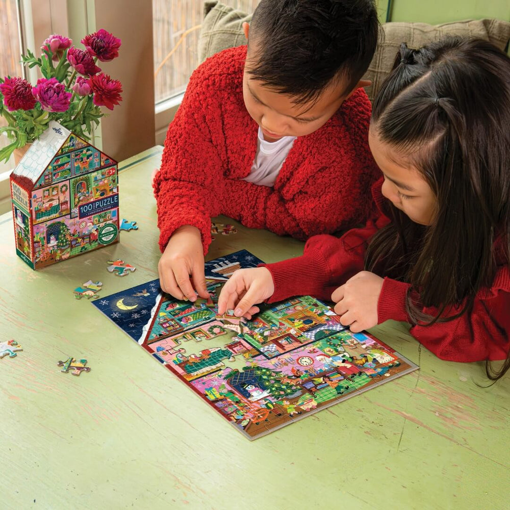 2 children put together the eeBoo Christmas House 100 pc Puzzle