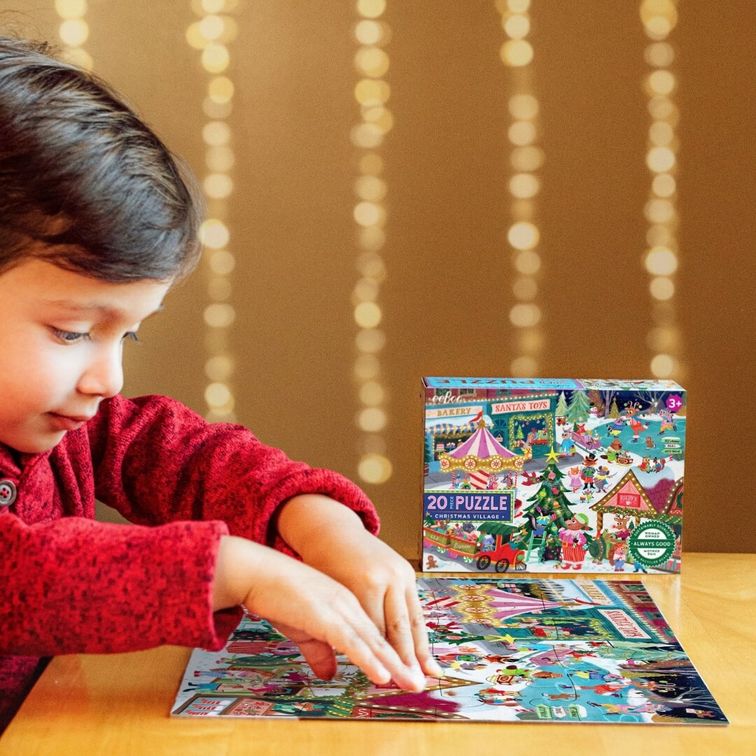 A child putting together the eeBoo Christmas Village 20 pc Puzzle