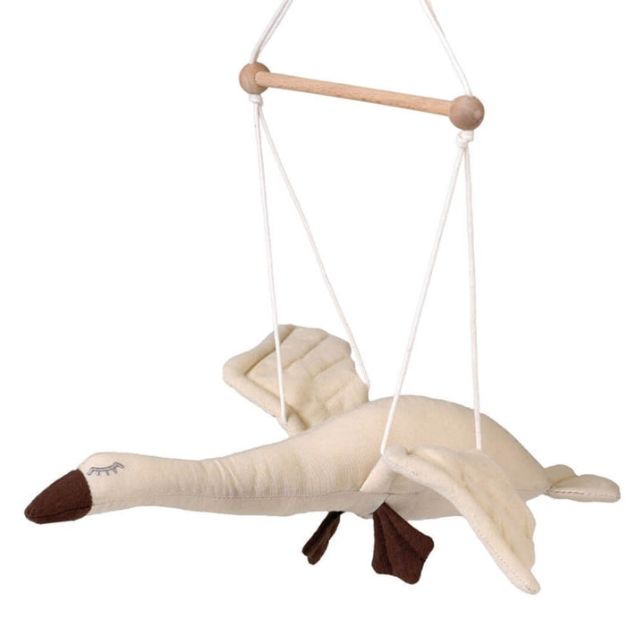 Cotton flying goose mobile with outstretched wings, hanging from a wooden rod with white cords shown against a white background. 
