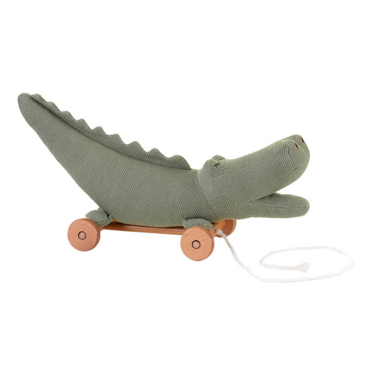 Green knitted alligator toy with wheels on a white background