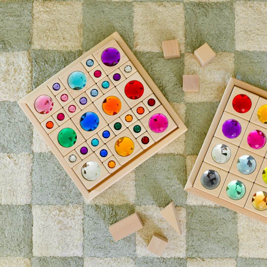Colorful wooden puzzle with embedded shining gem stones on a checkered surface