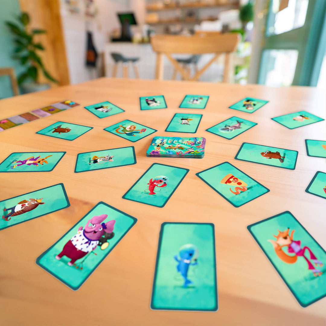Game cards with cartoon animals spread in a circle on a table.