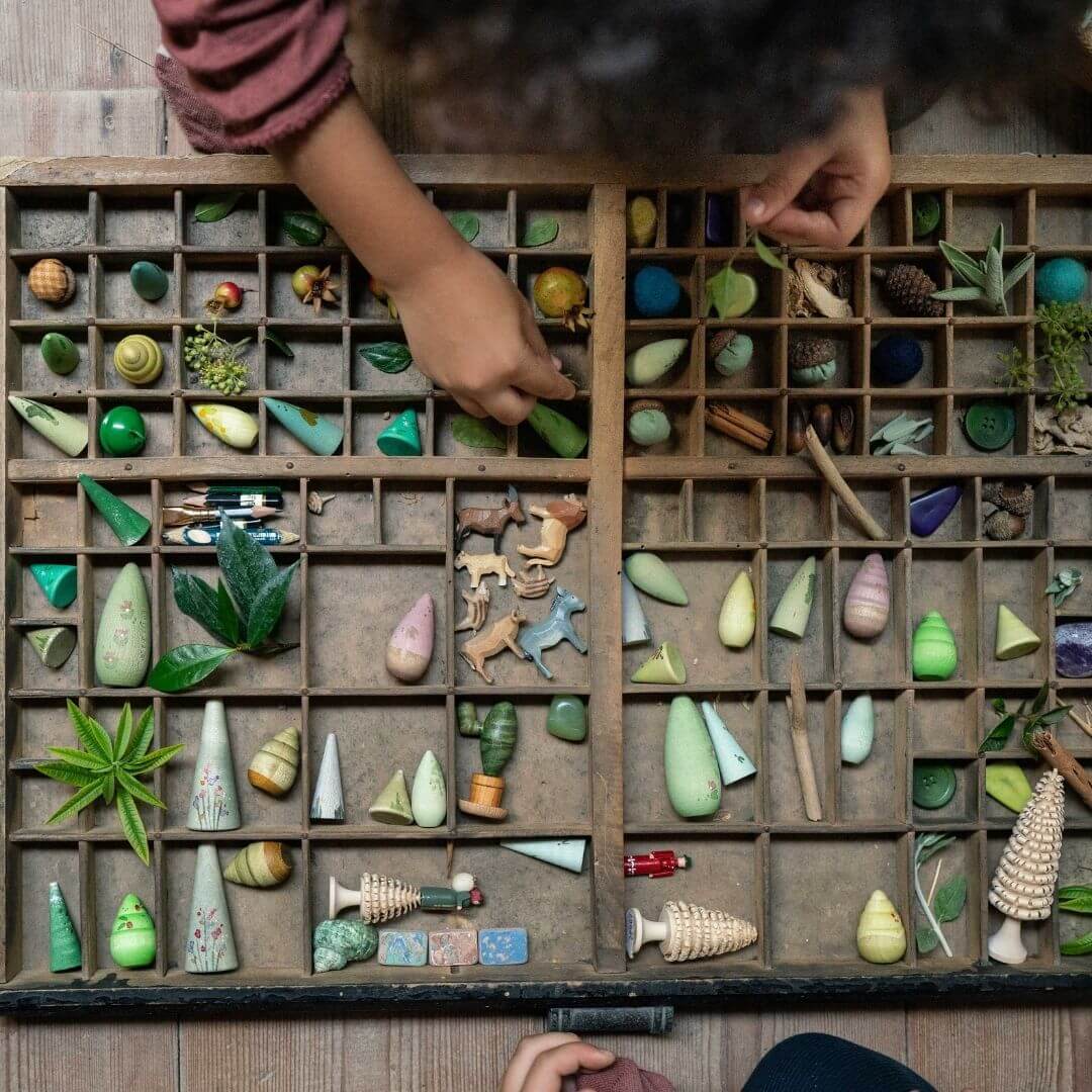 Grapat - A child playing with a wooden collection box with a variety of loose parts including Grapat Forest Tree set - Bella Luna Toys