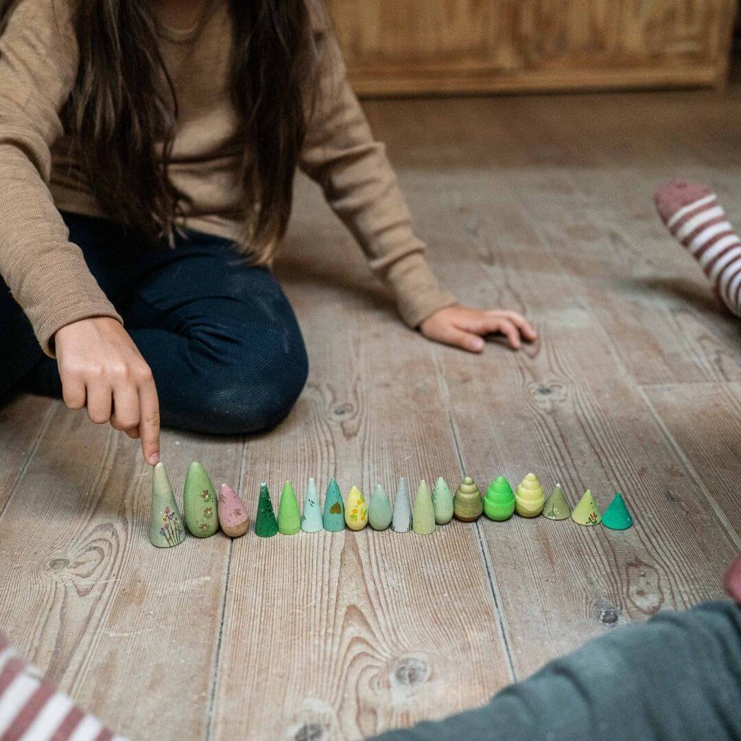 Child playing on the floor with Grapat Forest Trees wooden toy set for small world play, featuring 18 nature-inspired tree pieces - Bella Luna Toys - Bella Luna Toys