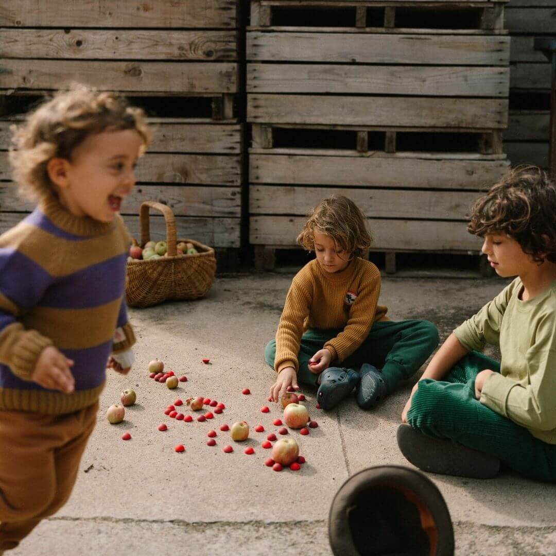 Children playing outside with Grapat Mandala Half Spheres set and apples with a basket of apples in the background - Bella Luna Toys