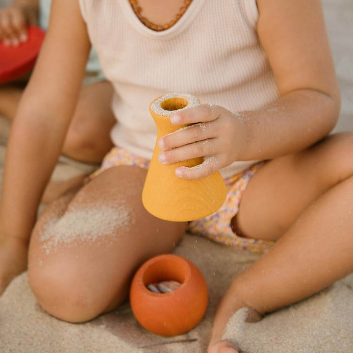 Child holding Grapat Pots vase with sand