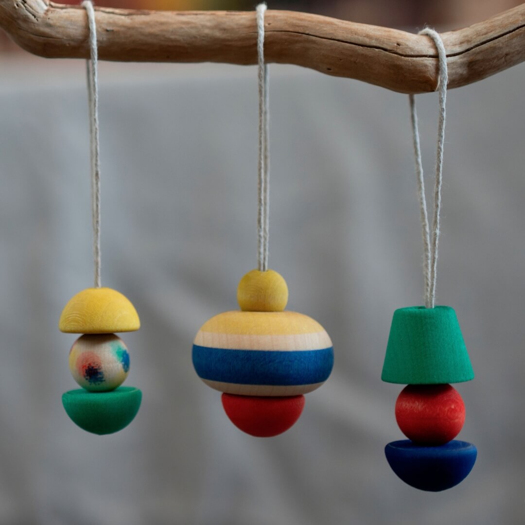 Grapat Pure Shine Wooden Christmas Ornaments hanging from a branch.