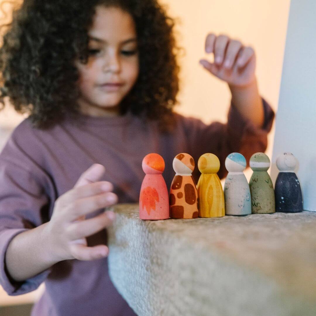 Grapat - Child playing with the six hand-painted Grapat wooden Nins dressed as animals - Bella Luna Toys