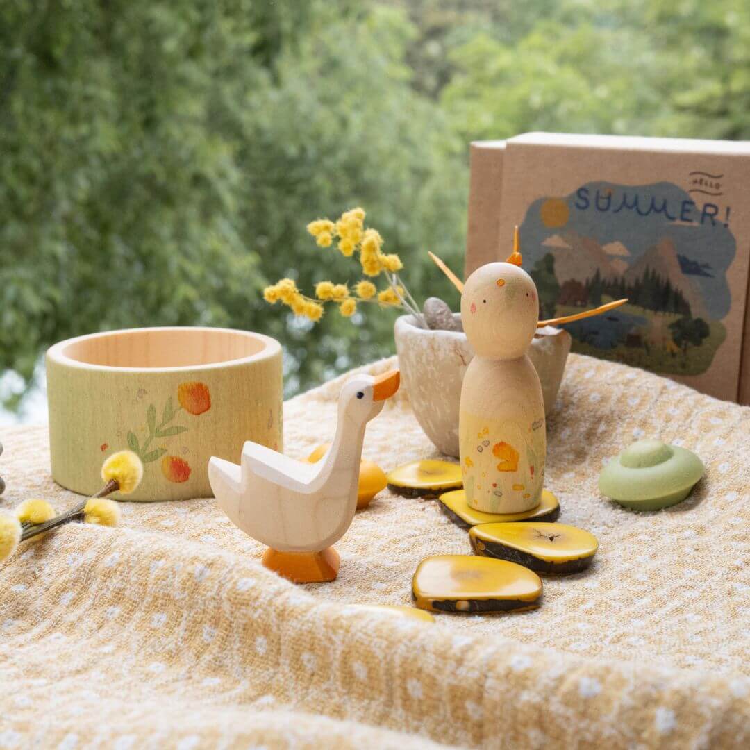 Complete Hello Summer set displayed outdoors, with wooden Nin, goose, bowl, and mandala pieces arranged on a cloth, capturing the seasonal spirit of the Grapat and Ostheimer collaboration.