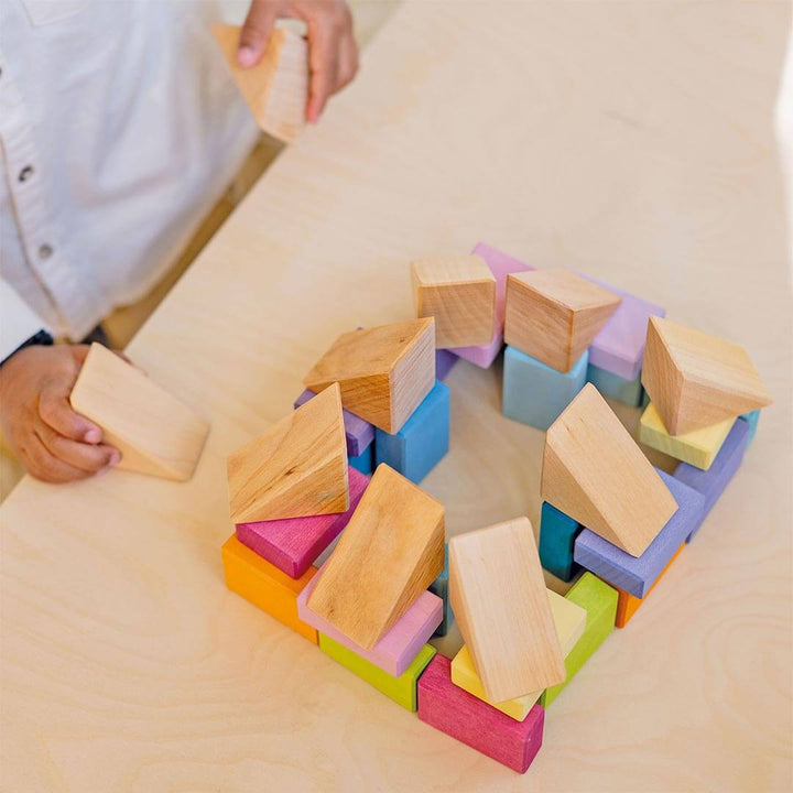 Child playing with Grimm's Pastel Duo Wooden Block Set