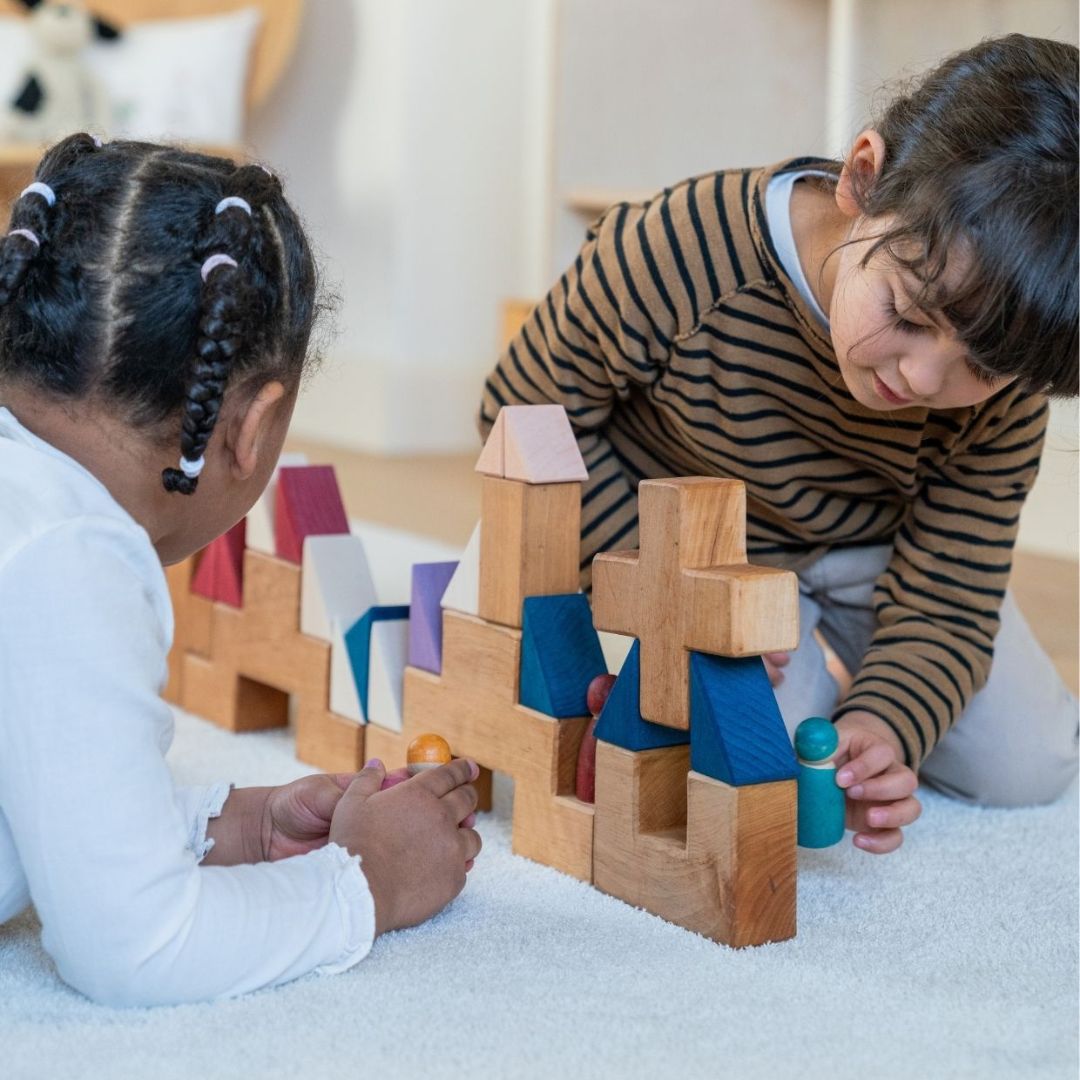 Children building with blocks from the Grimm's Wooden Toys Tiny Art Collection