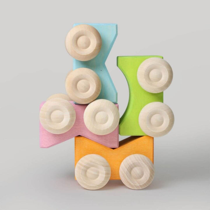 Set of Grimm’s stacking cars in yellow, green, and blue tones, stacked in playful combinations to highlight color harmony and imaginative building fun.