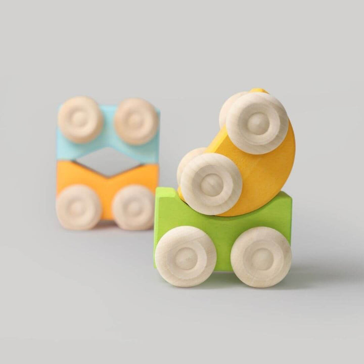 Set of Grimm’s stacking cars in yellow, green, and blue tones, stacked in playful combinations to highlight color harmony and imaginative building fun.