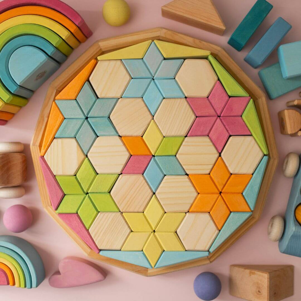 Grimm's exclusive Starry Night Dawn puzzle on a pink background surrounded by other pastel wooden toys.