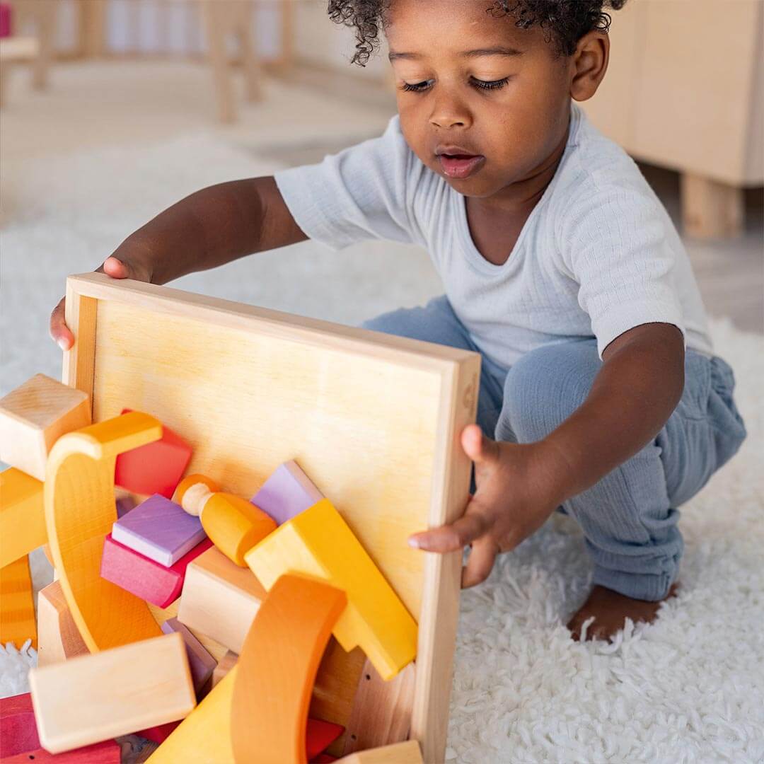 Child playing with Grimm's Wooden Building World Desert Sand