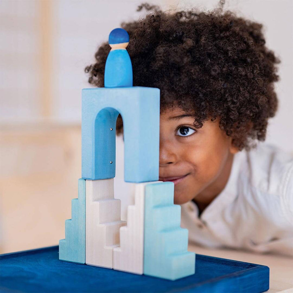 Child playing with Grimm's Wooden Building World Polar Light Set