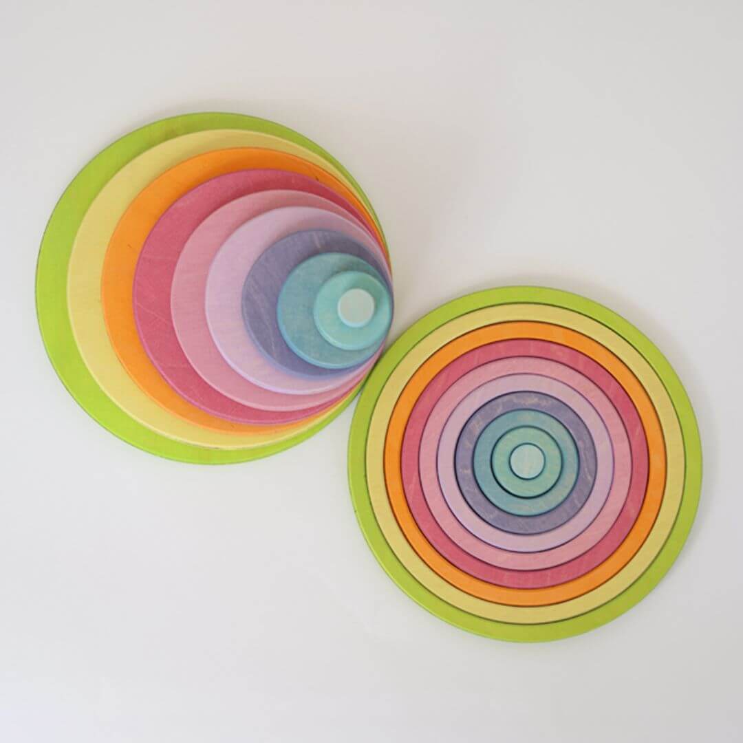 Grimm's pastel concentric circles and rings arranged in two piles flat on a white background, showcasing soft rainbow hues from mint green to lavender.