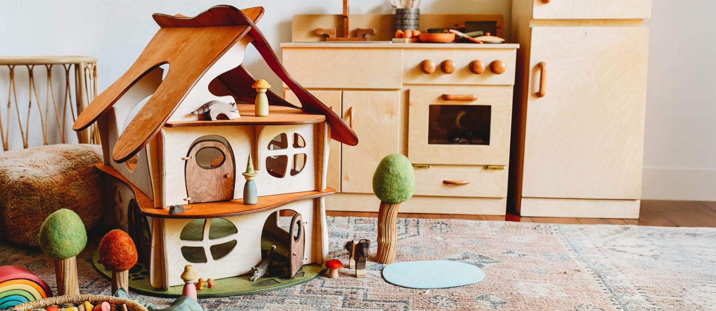 Wooden dollhouse with accessories on a rug in a room with wooden furniture.