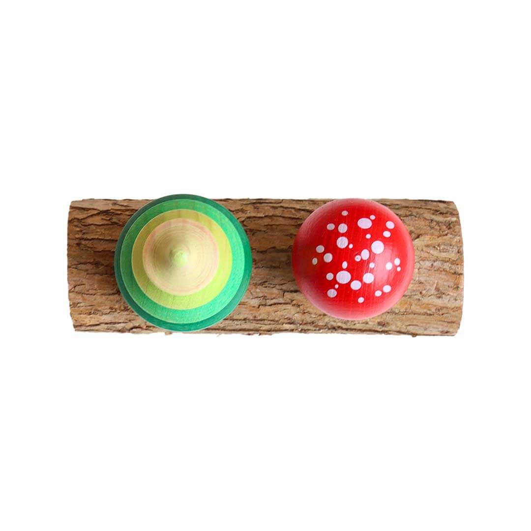 Two colorful wooden toys on a log with a white background