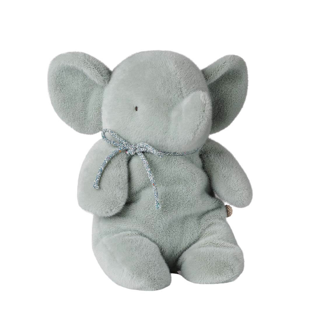 A light blue plush elephant toy with a small silver glitter bow tied around its neck, shown against a plain white background.