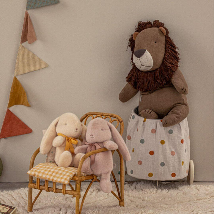 Maileg Big Lion displayed in a cozy playroom setting alongside Maileg bunnies, a rattan chair, and soft décor accents, creating a warm imaginative scene. Bella Luna Toys