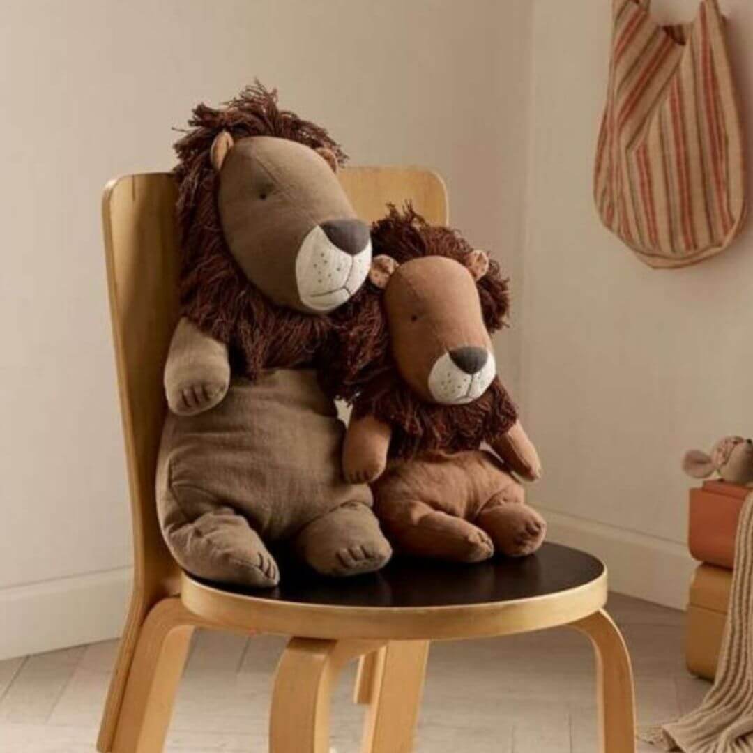 Maileg Big Lion siting next to a smaller lion on a chairn displayed in a cozy playroom, creating a warm imaginative scene. Bella Luna Toys