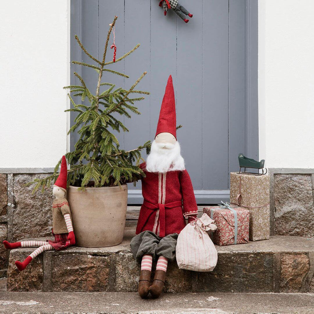 Maileg Large Santa displayed sitting outside near a Maileg pixie in a holiday setting with seasonal décor, highlighting his handcrafted clothes and tall, festive presence. Bella Luna Toys