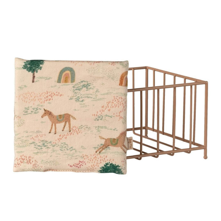 Reverse side of the Maileg play pen blanket with a unicorn print on it.