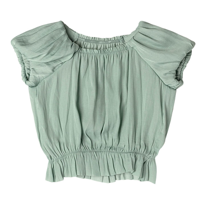 Light green blouse with ruffled shoulders on a white background