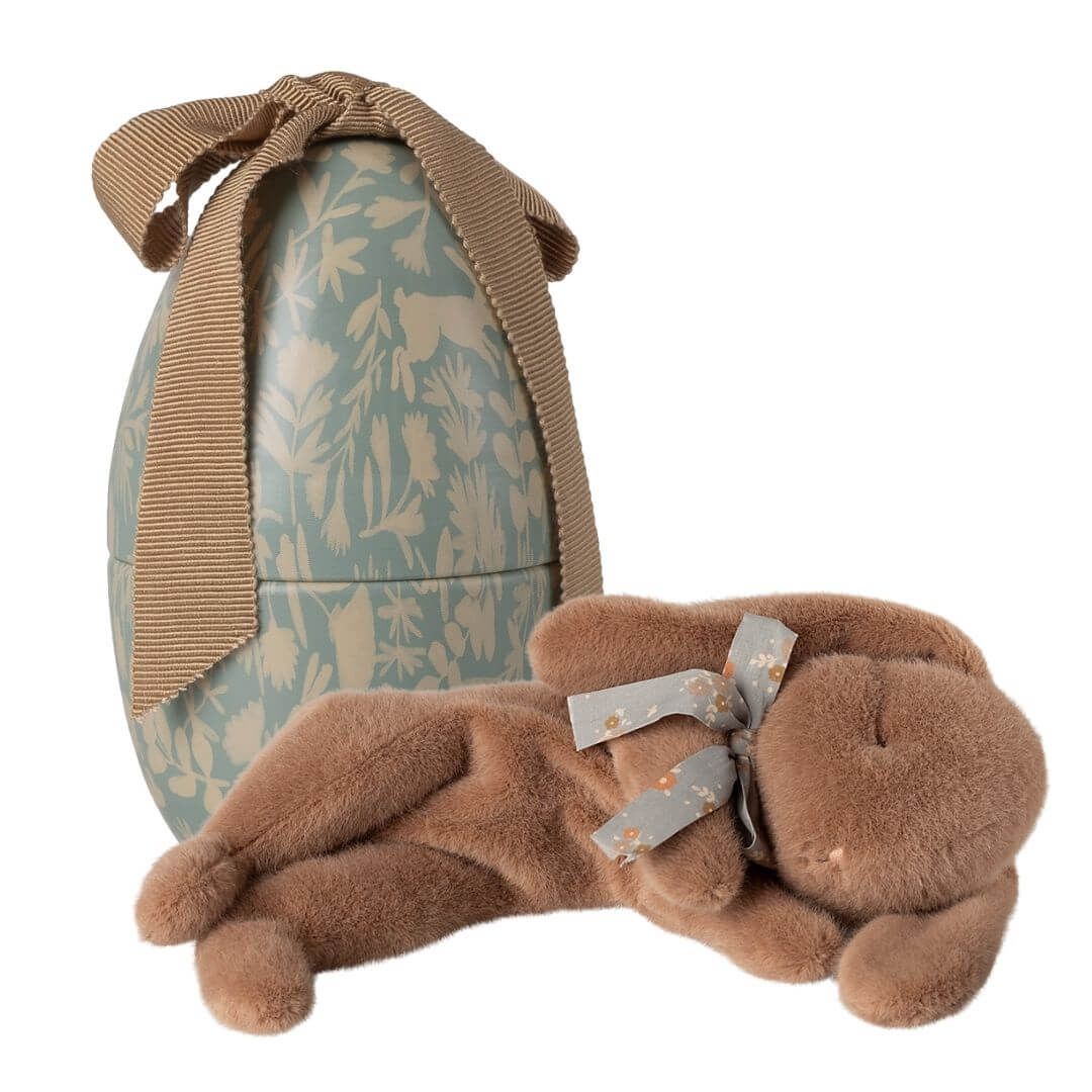 Maileg Sleeping Bunny plush with ribbon collar nestled inside dusty blue floral metal Easter egg with fabric bow