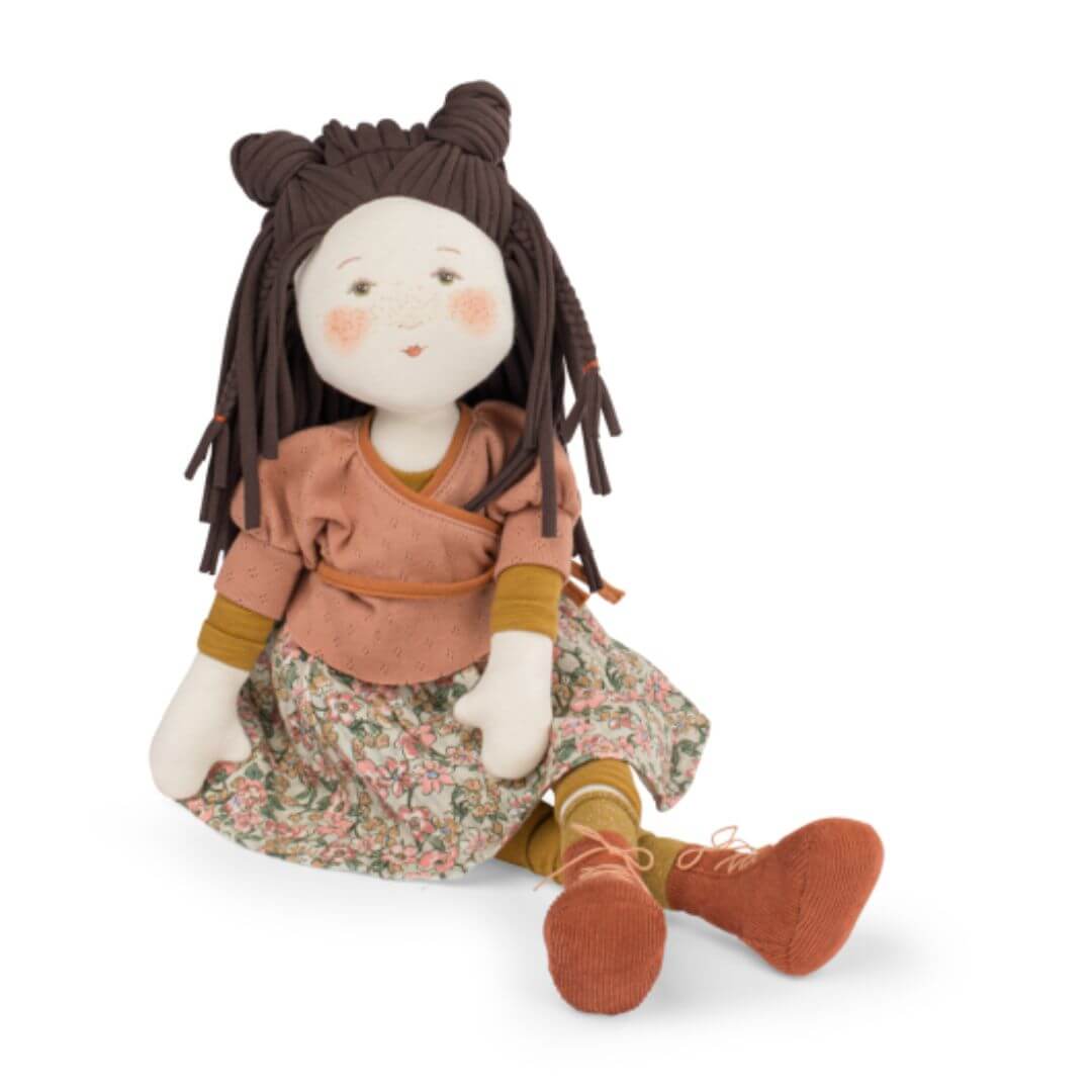 Moulin Roty - Brown haired doll with a pink top and floral skirt sitting with legs crossed. Bella Luna Toys