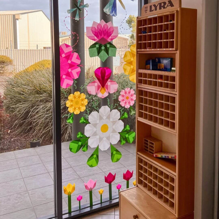 Decorative floral window folded Japanese silk paper  on a glass door with a wooden shelf.