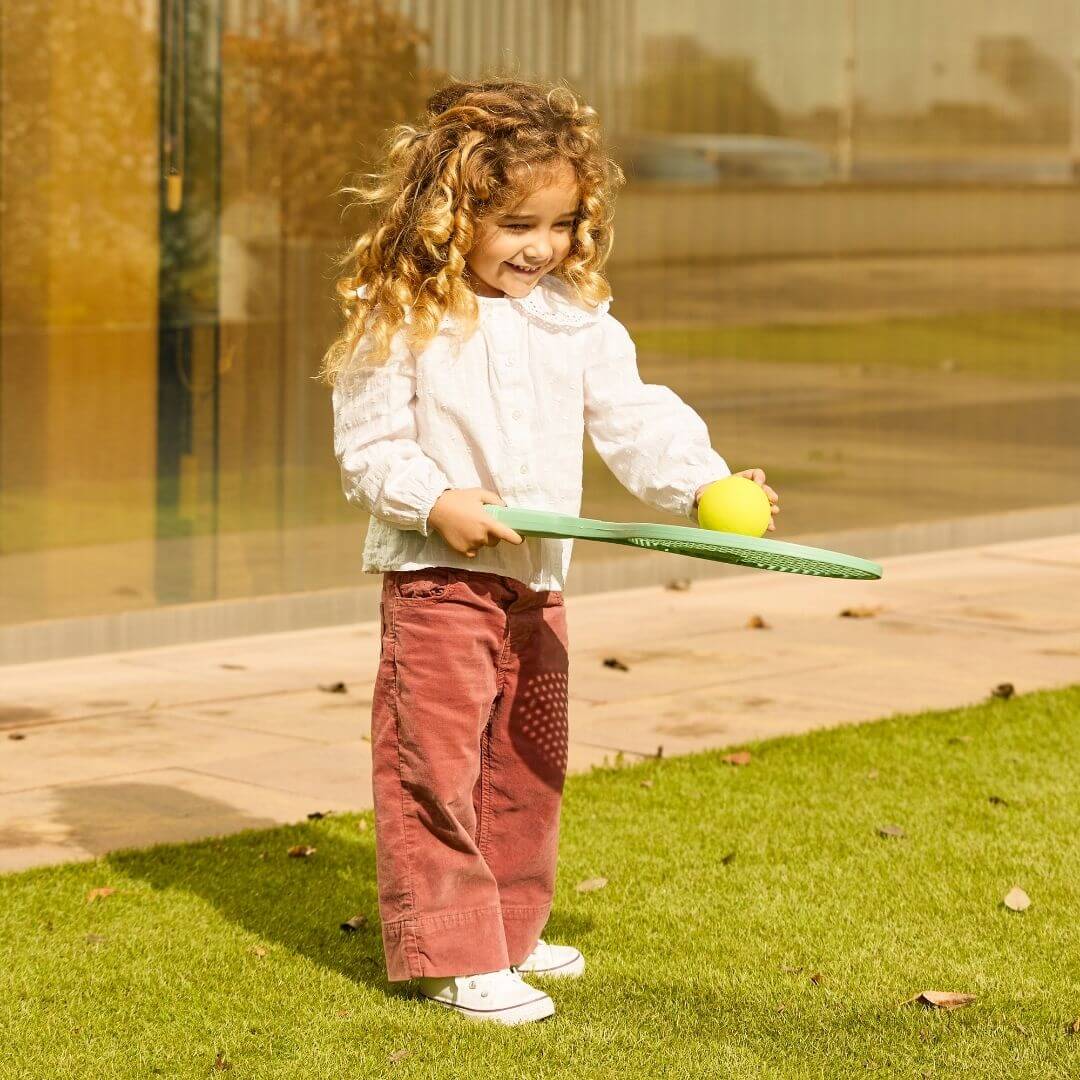 A child playing with the Miniland Eco Racket and Ball Set