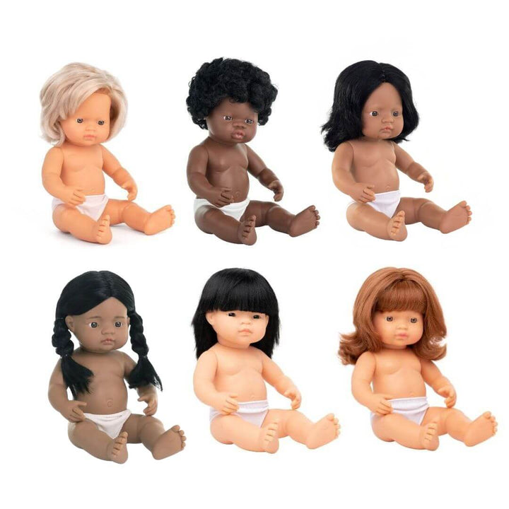 A set of five Miniland Realistic Montessori Dolls, representing Blonde, Red-Haired, Black, Hispanic, and Asian ethnicities. Each 12-inch anatomically correct girl doll is crafted from soft vinyl, designed for educational and inclusive play.