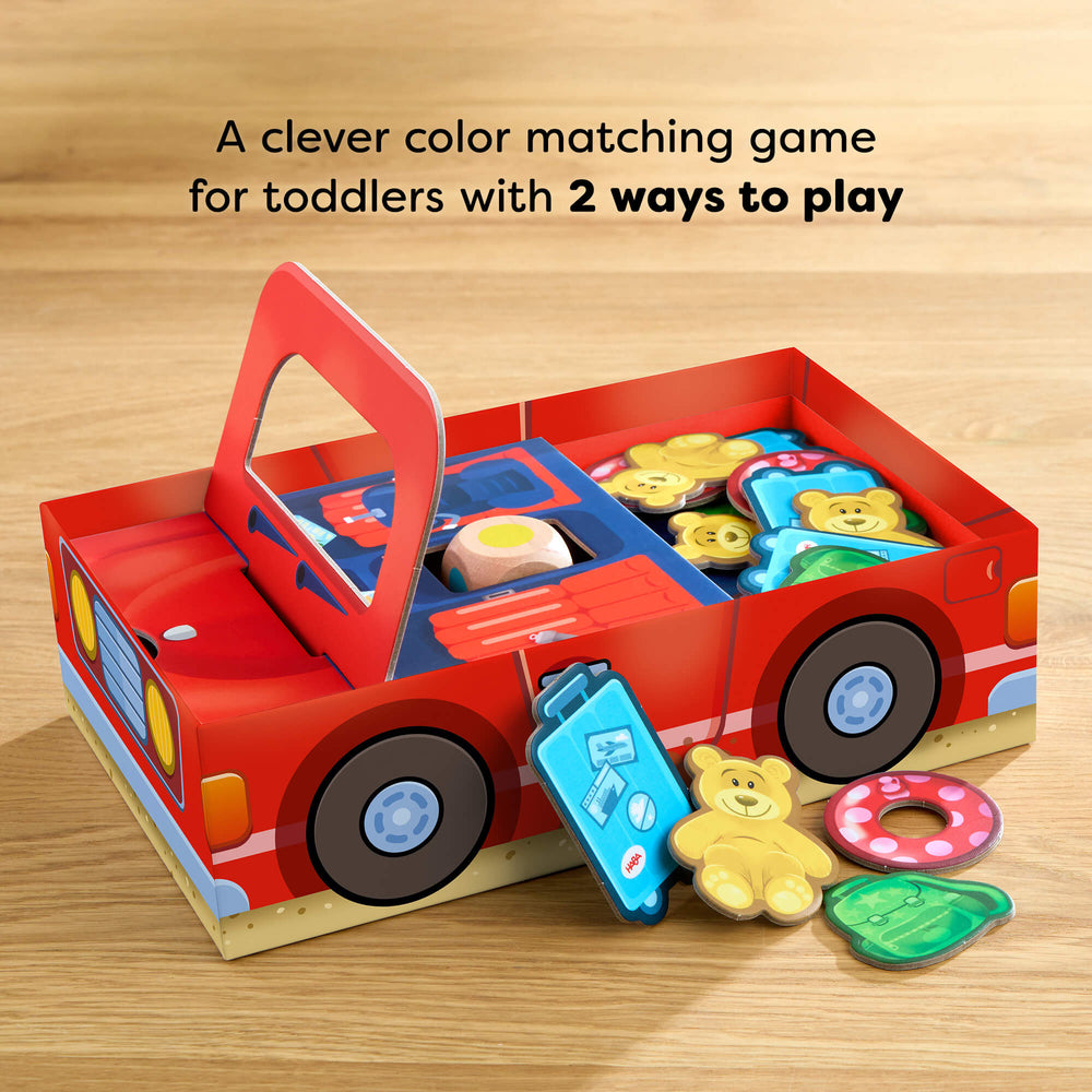 Color matching game for toddlers in a red car-shaped box on a wooden surface. HABA games.