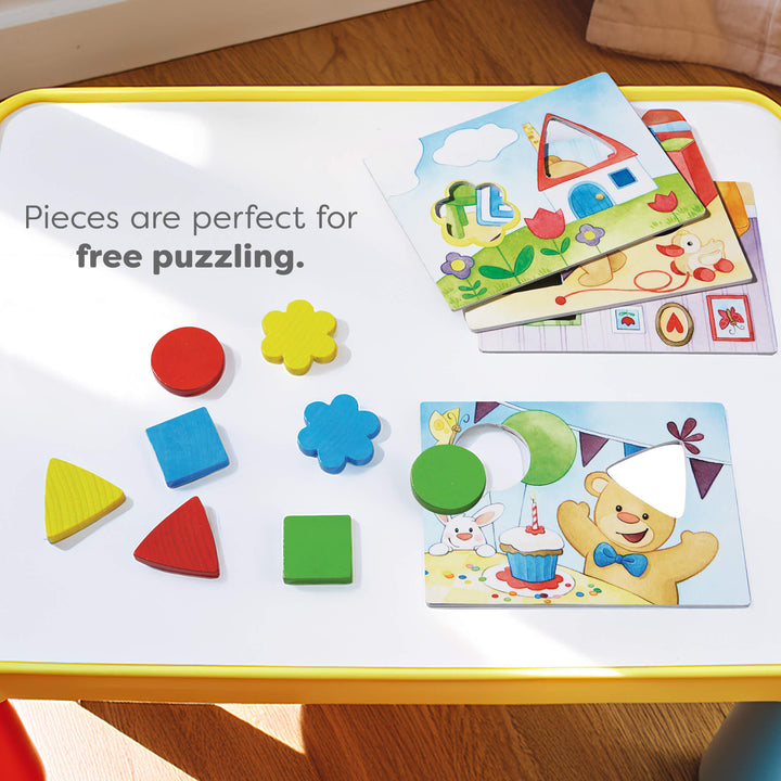 Colorful geometric puzzle pieces and templates on a yellow-bordered table.Text reads "Pieces are perfect for free puzzling."
