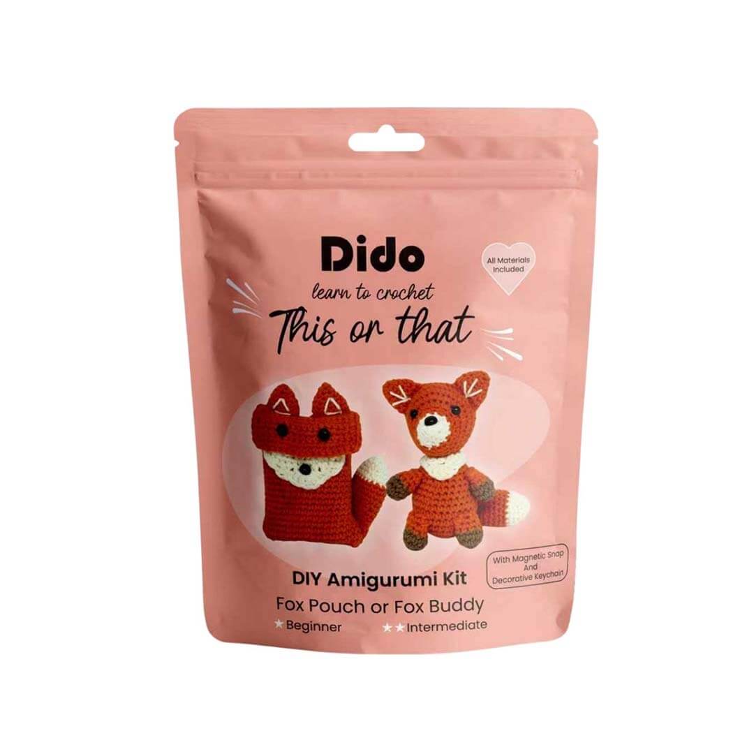 A pink stand-up pouch package for a DIY Amigurumi Kit called 'Dido learn to crochet This or that'. The front of the packaging features illustrations of a crocheted fox pouch and a crocheted fox toy in red, white, and brown.