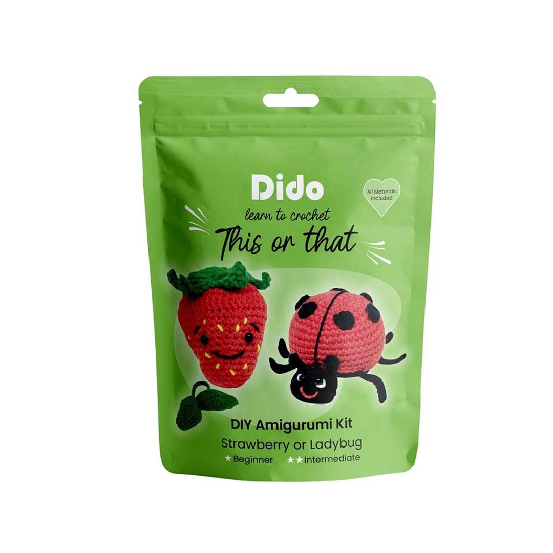 A green stand-up pouch package for a DIY Amigurumi Kit by Dido, featuring crocheted illustrations of a strawberry and a ladybug on a white background.
