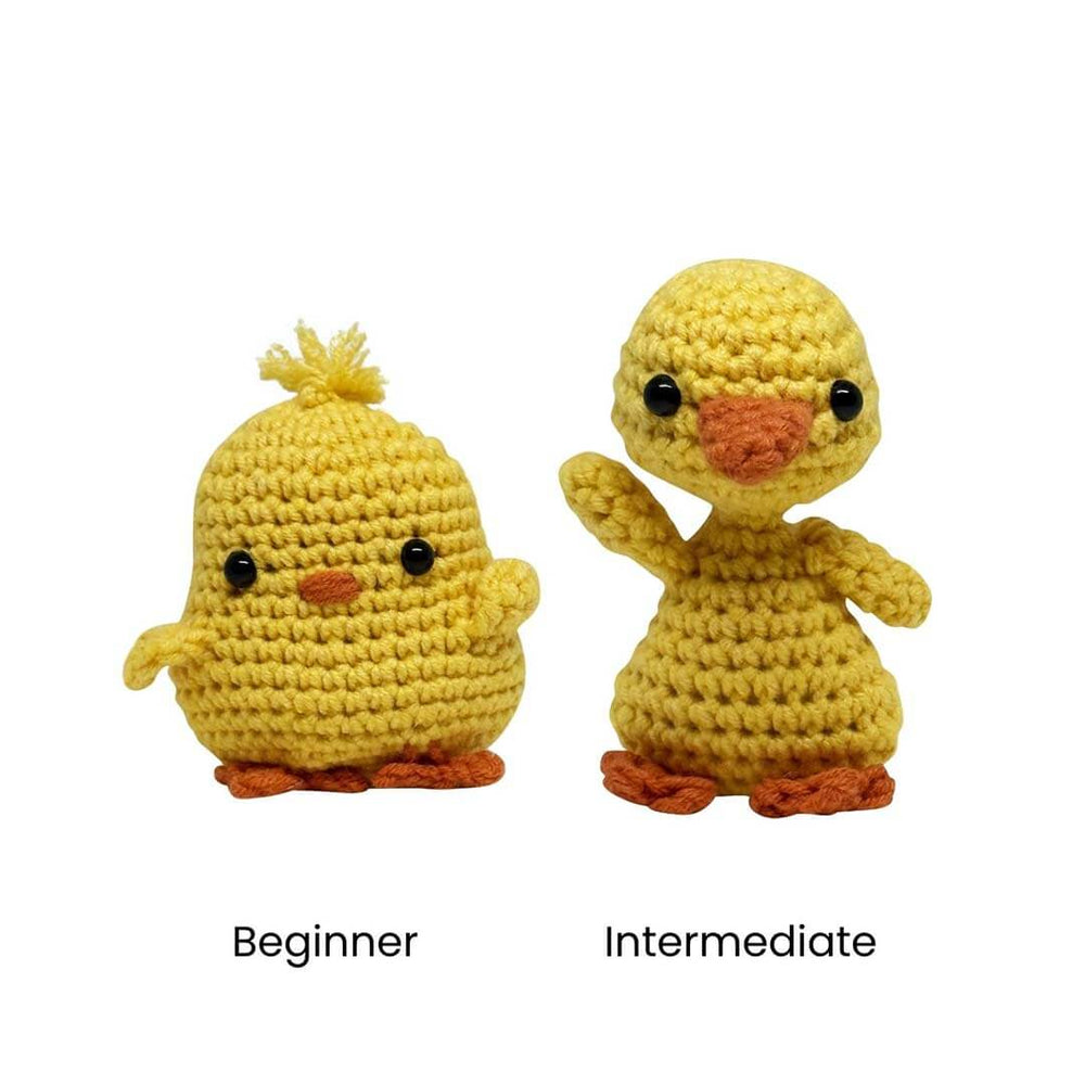 Two crocheted yellow chick figures on a white background, labeled Beginner and Intermediate below them. The left chick is smaller with a tufted yellow crest and orange feet/beak; the right chick is larger with wings visible and orange feet/beak.